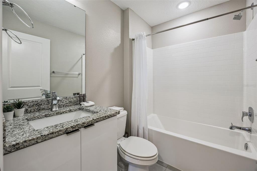 8008 Formosa Valley Place Kissimmee, FL 34747 - Photo 25 of 55 a bathroom with a granite countertop sink toilet and shower