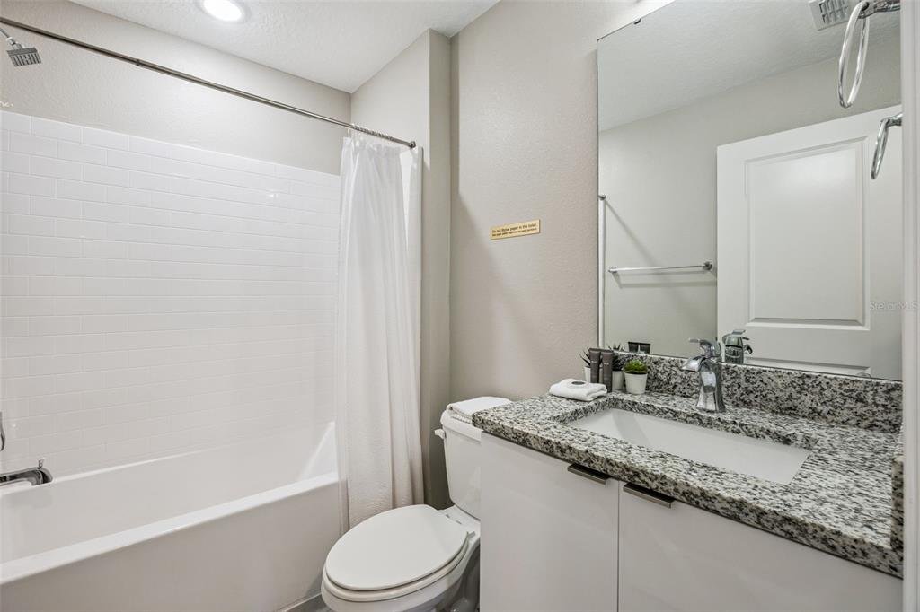 8008 Formosa Valley Place Kissimmee, FL 34747 - Photo 26 of 55 a bathroom with a granite countertop sink toilet and shower