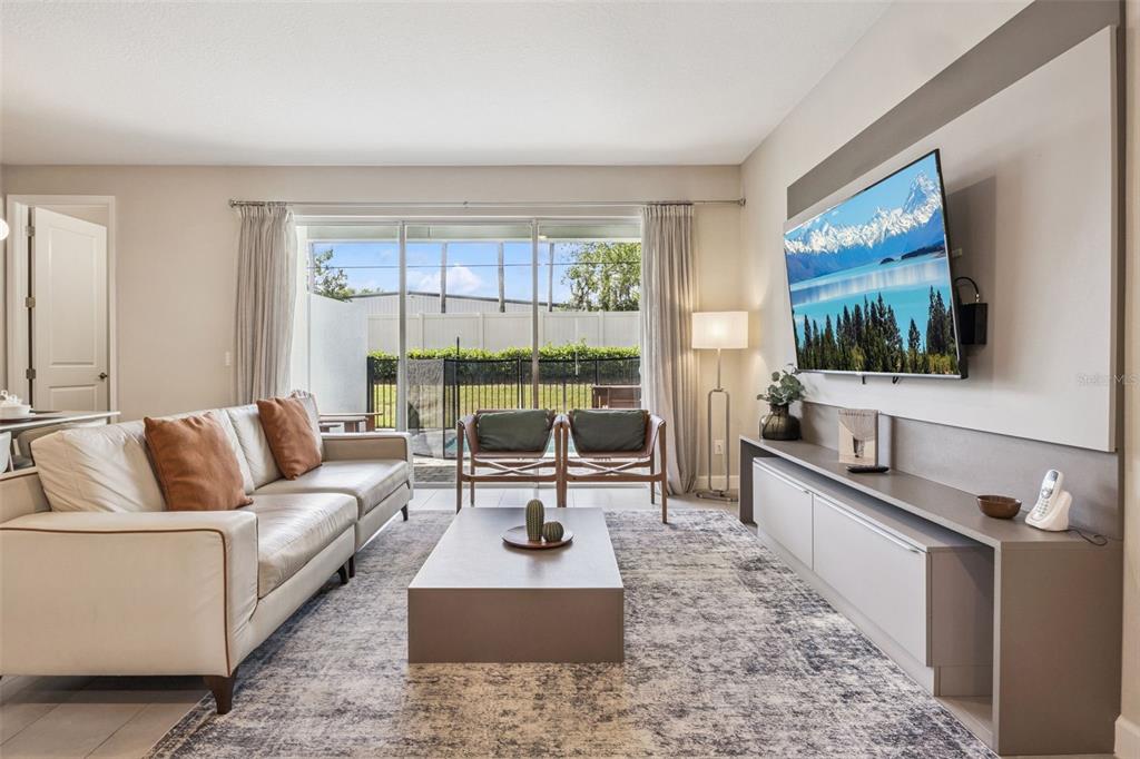 8008 Formosa Valley Place Kissimmee, FL 34747 - Photo 3 of 55 a living room with furniture large window and flat screen tv