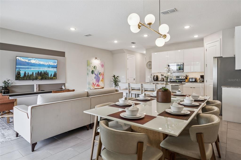 8008 Formosa Valley Place Kissimmee, FL 34747 - Photo 6 of 55 a kitchen with a dining table cabinets and stainless steel appliances