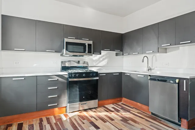 a kitchen with stainless steel appliances granite countertop a sink and stove top oven
