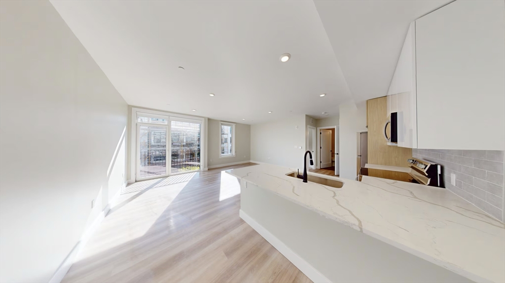 a view of a living room hardwood floor and a large window
