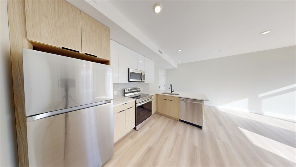 211 Green Street, Unit 401 Boston, MA 02130 - Photo 2 of 11 a kitchen with white cabinets and white appliances