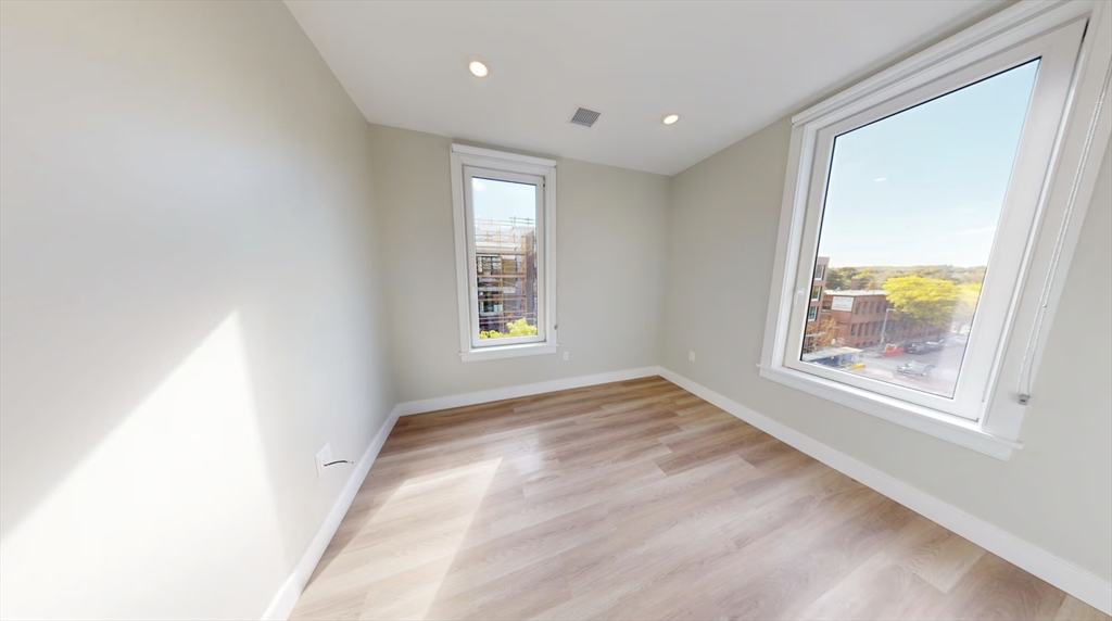 211 Green Street, Unit 401 Boston, MA 02130 - Photo 4 of 11 an empty room with windows