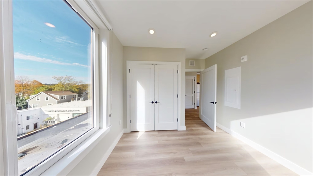 211 Green Street, Unit 401 Boston, MA 02130 - Photo 5 of 11 a view of a hallway with wooden floor and windows