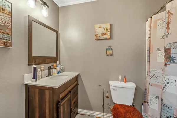 a bathroom with a toilet sink and mirror