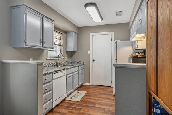 a kitchen with granite countertop a sink and cabinets