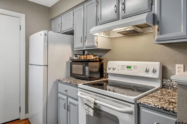 a kitchen with stainless steel appliances granite countertop a refrigerator and a stove