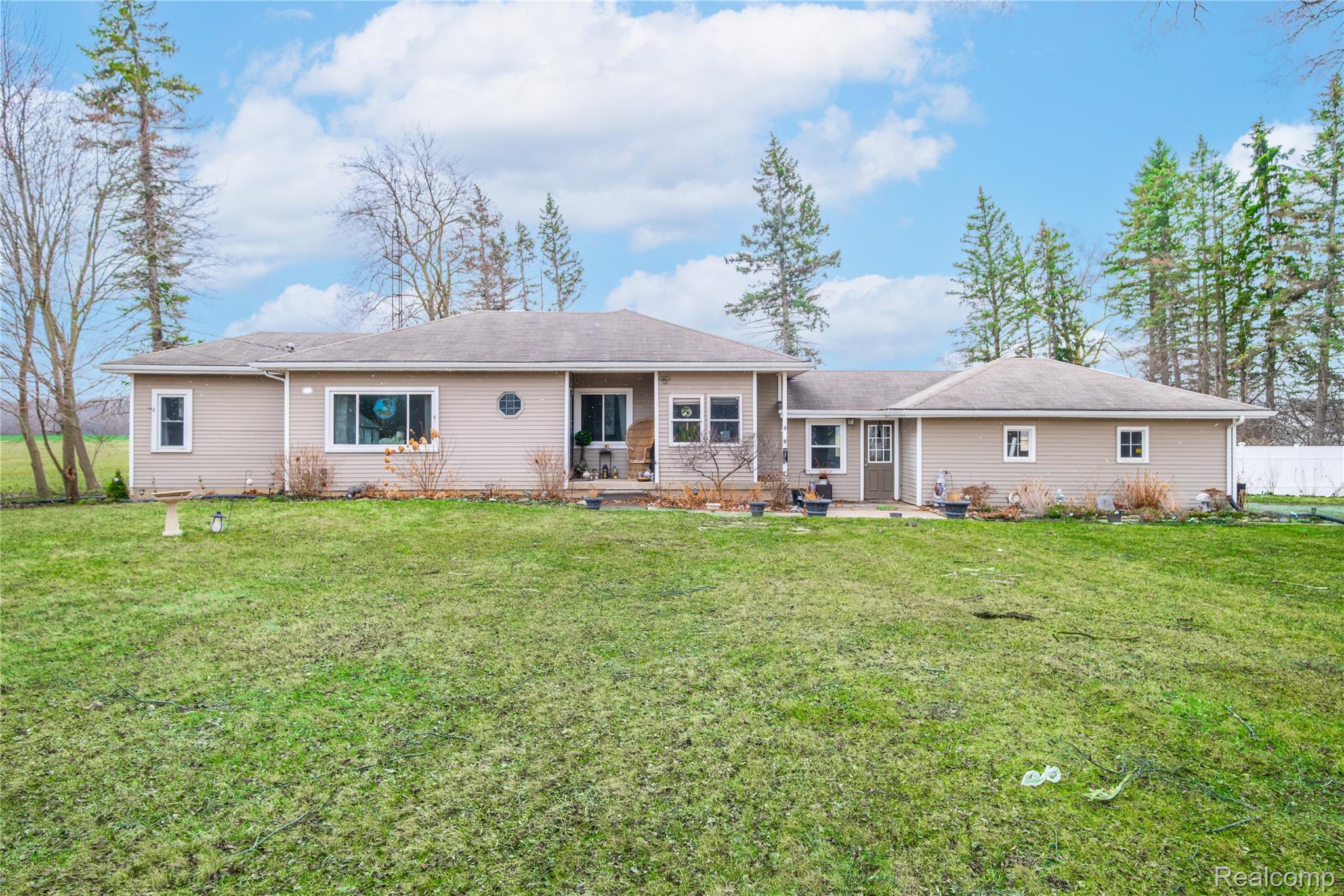 Rear view of property featuring a lawn and a patio
