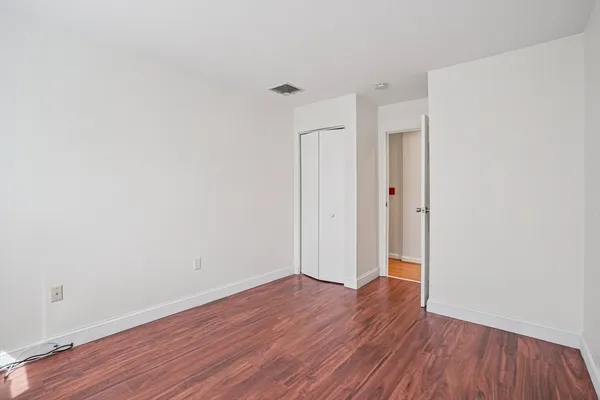a view of wooden floor and a chandelier fan in a room