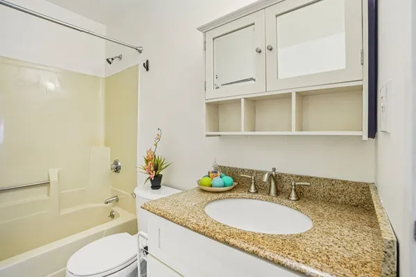 a bathroom with a sink mirror and toilet