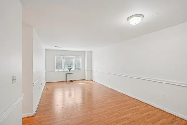 a view of a room with wooden floor and white walls