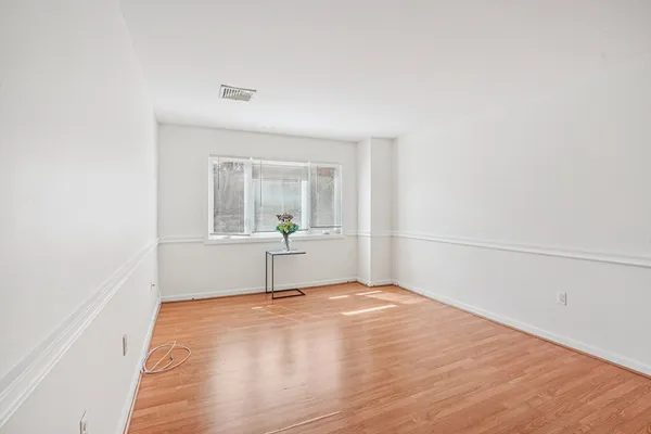 a view of empty room with wooden floor