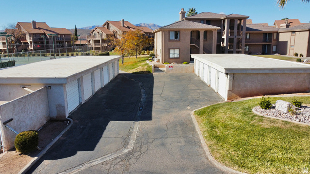 860 South Village Road, Unit Y8 St. George, UT 84770 - Photo 23 of 29 View of asphalt driveway featuring a residential view and community garages