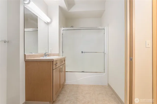 a bathroom with a shower sink and mirror
