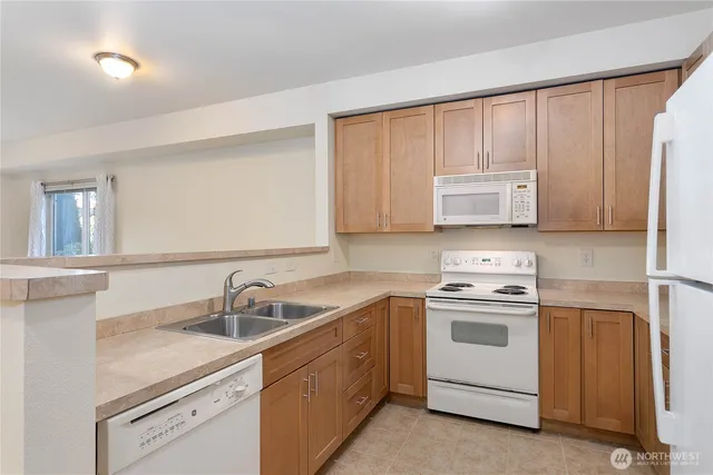 a kitchen with white cabinets sink and appliances