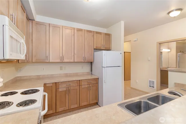 a kitchen with a refrigerator sink stove and cabinets