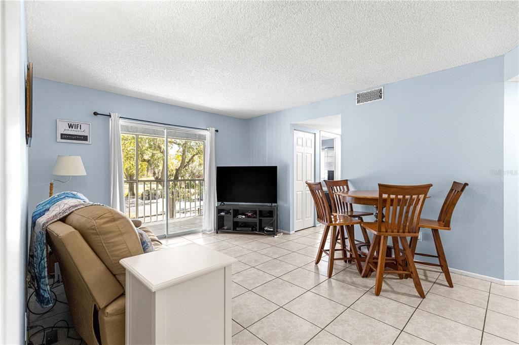 588 Fairways Lane, Unit E201 Ocala, FL 34472 - Photo 18 of 33 a view of a dining room with furniture and a flat screen tv