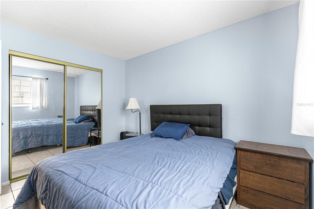 588 Fairways Lane, Unit E201 Ocala, FL 34472 - Photo 24 of 33 a bedroom with a bed and a mirror