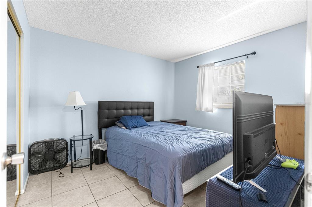 588 Fairways Lane, Unit E201 Ocala, FL 34472 - Photo 25 of 33 a bedroom with a bed and a chair