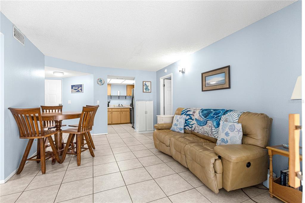 588 Fairways Lane, Unit E201 Ocala, FL 34472 - Photo 4 of 33 a living room with furniture and a dining table with kitchen view