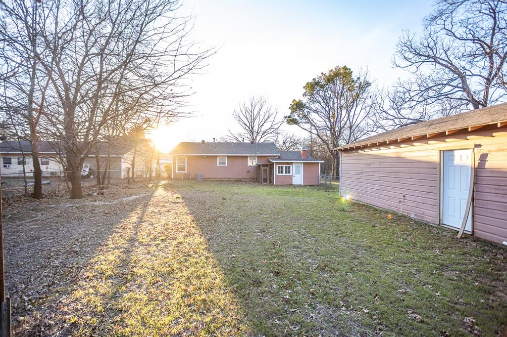 1414 Rice Avenue Gainesville, TX 76240 - Photo 20 of 21 a view of a yard with a house and a large tree