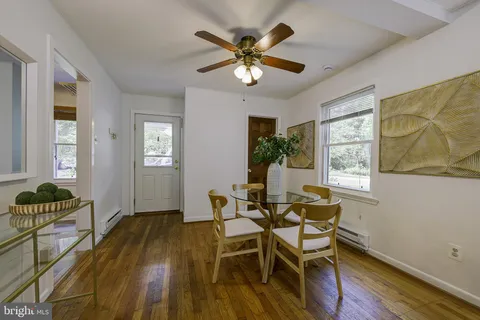 a dining room with chandelier and wooden floor