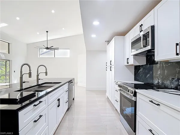 a kitchen with stainless steel appliances granite countertop a sink and cabinets