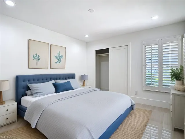 a bedroom with a large bed and a window