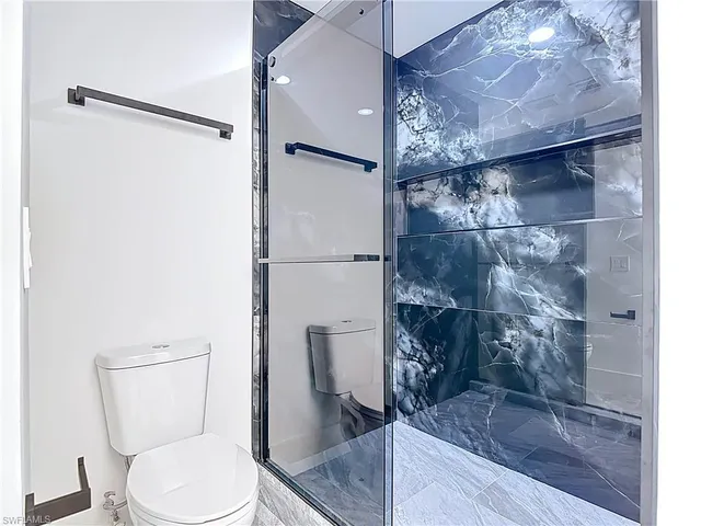a bathroom with a toilet and a shower