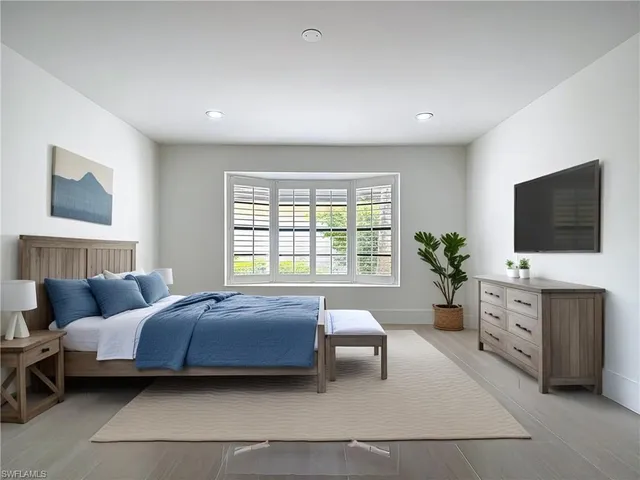 a bedroom with a bed and a flat screen tv