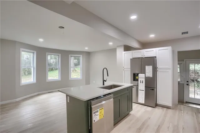 a kitchen with stainless steel appliances granite countertop a sink stove and refrigerator