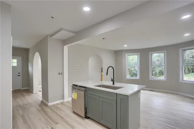 a kitchen with a sink cabinets and wooden floor