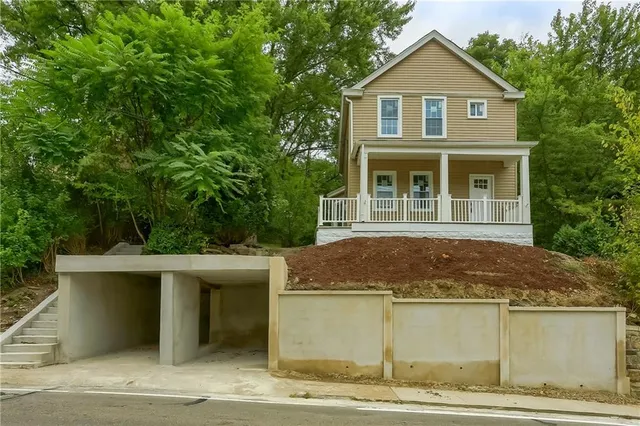 a front view of a house with a garden