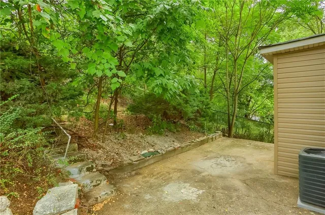 a view of a yard with plants and wooden fence