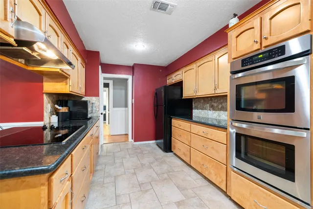 a kitchen with stainless steel appliances granite countertop a stove and a microwave