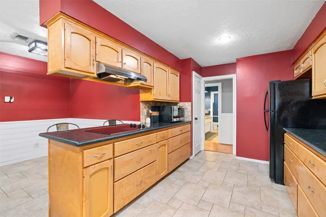 a kitchen with stainless steel appliances granite countertop a stove a refrigerator and a microwave