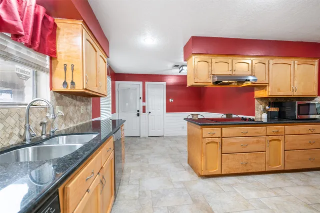 a kitchen with granite countertop a sink and a cabinets