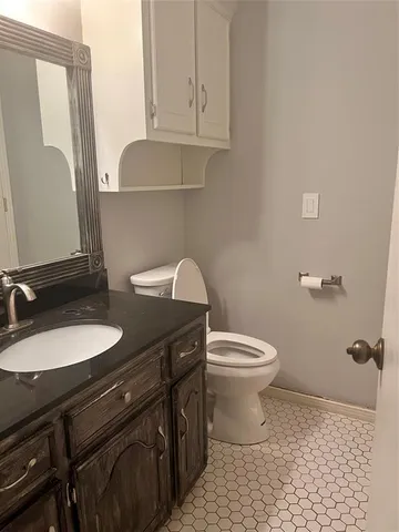 a bathroom with a granite countertop sink toilet and mirror