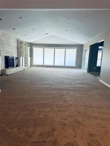 a view of empty room with windows and ceiling fan