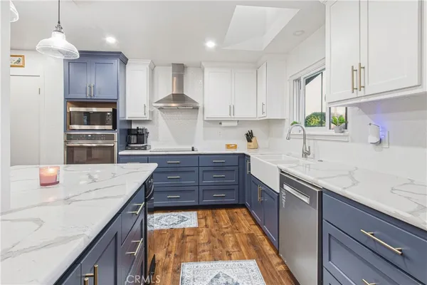 a kitchen with kitchen island granite countertop a sink stove and cabinets