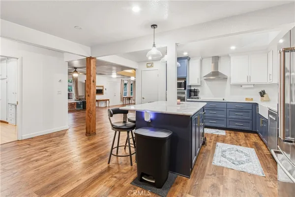 a kitchen with granite countertop wooden floors and a view of living room