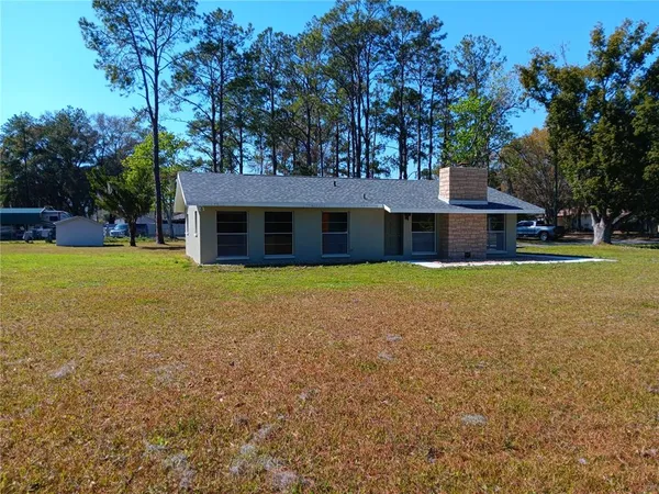 a view of a house with a yard and a tree