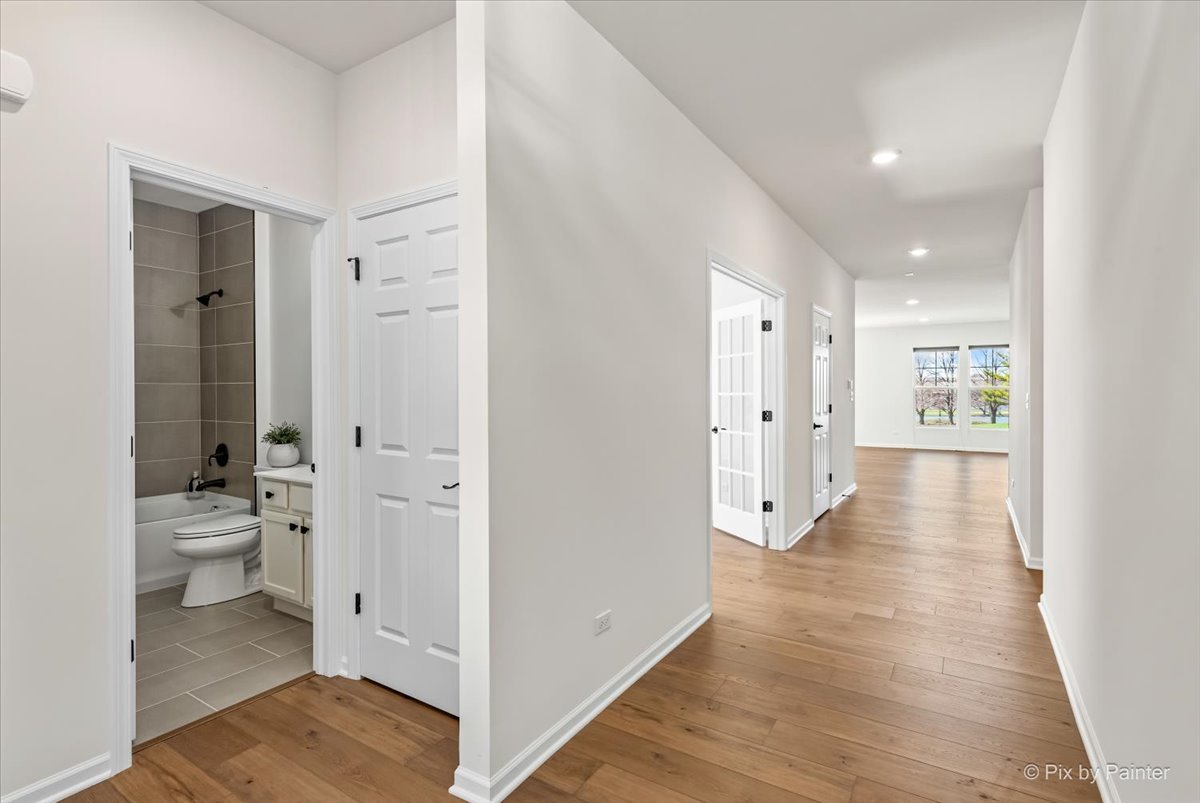 23116 Pinehurst Drive Kildeer, IL 60047 - Photo 3 of 27 a view of a hallway with wooden floor and a bathroom