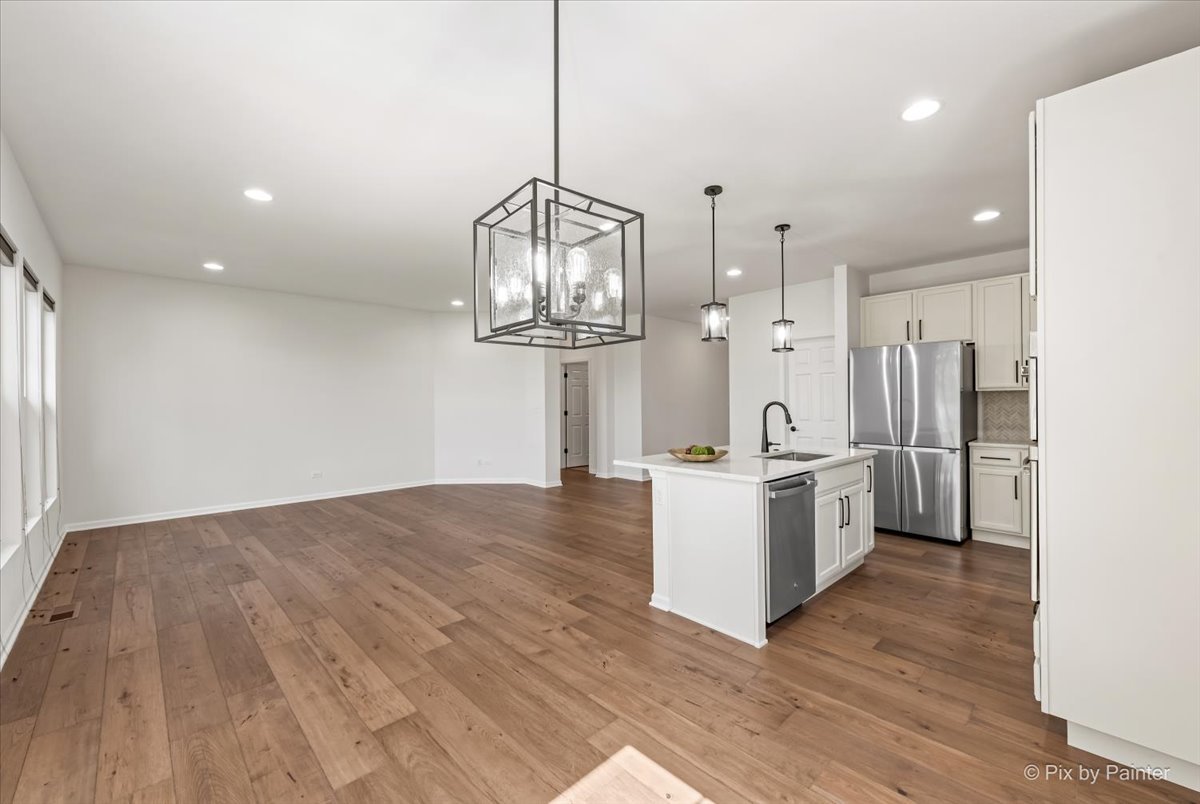 23116 Pinehurst Drive Kildeer, IL 60047 - Photo 7 of 27 a large kitchen with stainless steel appliances a large counter top a sink a refrigerator and a wooden floor