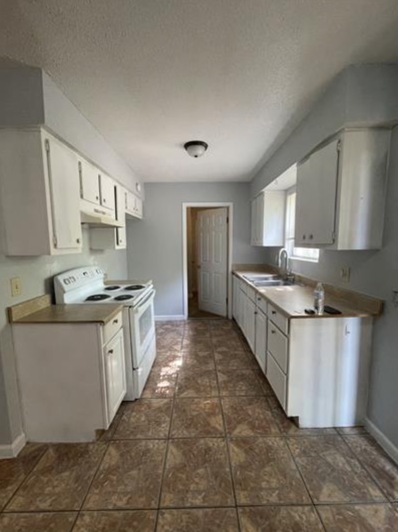 105 Cockerham Street, Unit A Kyle, TX 78640 - Photo 2 of 9 a large kitchen with stainless steel appliances granite countertop a stove a sink and a refrigerator