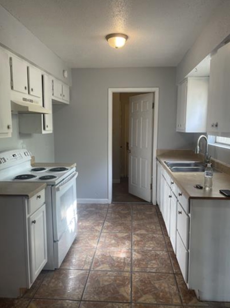 105 Cockerham Street, Unit A Kyle, TX 78640 - Photo 3 of 9 a kitchen with a sink stove and cabinets