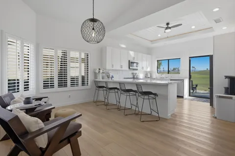 a living room with stainless steel appliances kitchen island granite countertop furniture and a large window