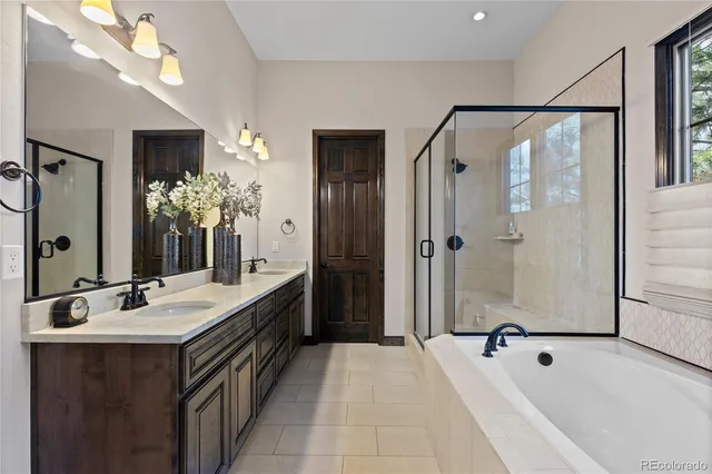 a spacious bathroom with a tub sink shower and mirror