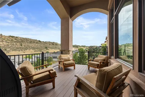 an outdoor living room with patio furniture and a floor to ceiling window